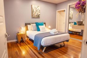 a bedroom with a bed with blue and white pillows at Fig Tree Luxury Guest House in Pokolbin +41 photos