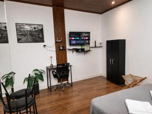 a bedroom with a bed and a tv on a wall at NOVO! Studio in Ouro Preto