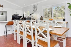 a white dining room with a table and chairs at Lamp Estate in Greta +26 photos