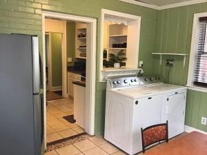 a kitchen with green walls and a white washer at Cute 2 bedroom house in Augusta in Augusta