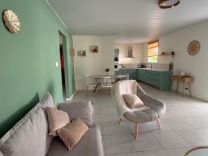 a living room with a couch and a kitchen at Villa de charme à Matoury in Matoury