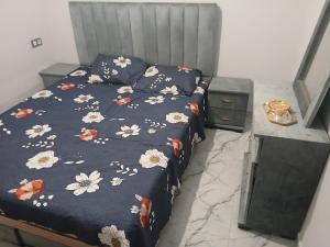 a bedroom with a bed with a blue comforter with flowers at 925 تجزئة الفتح خريبكة 5 in Khouribga