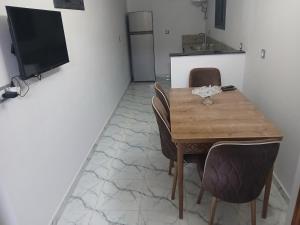 a kitchen with a wooden table and chairs and a television at 925 تجزئة الفتح خريبكة 5 in Khouribga