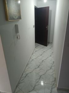 a hallway with a black door and a marble floor at 925 تجزئة الفتح خريبكة 5 in Khouribga