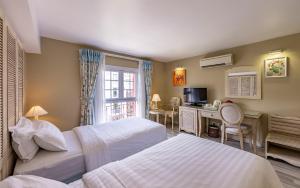 a hotel room with two beds and a desk at Hotel L Odeon Phu My Hung in Ho Chi Minh City +64 photos