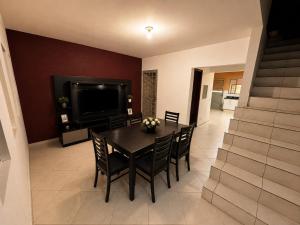 a dining room with a table and chairs and a television at Morada 360 Casa Inteira para até 09 Pessoas in Sumaré