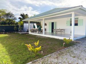 a white house with a patio and a yard at Villa de charme à Matoury in Matoury