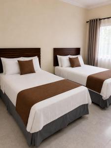 two beds in a hotel room with two beds at Hotel Comfort Trujillo in La Milagrosa