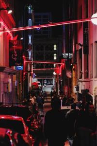 a crowd of people walking down a city street at night at Sun Soaked Corner Apartment with Harbour View in Auckland
