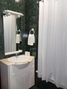 a bathroom with a sink and a white shower curtain at Casa D'Afife in Afife +29 photos