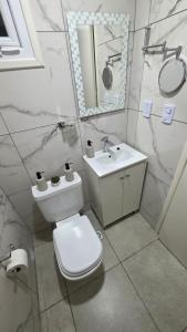 a bathroom with a toilet and a sink and a mirror at Departamento VMV in Río Grande