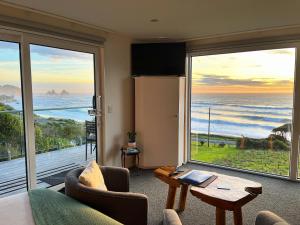 a living room with a view of the ocean at View With A Room NZ - Boutique Beachfront Accommodation on the Great Coast Road in Runanga