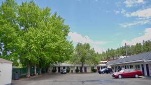 a red car parked in a parking lot next to buildings at Relax Inn in Flagstaff
