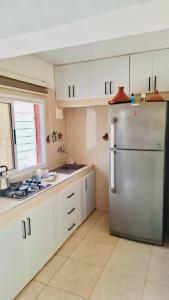 a kitchen with a stainless steel refrigerator and white cabinets at Family villa in Marrakesh