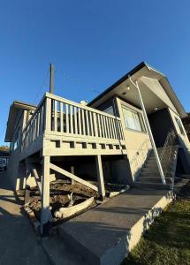 a house with a wooden porch and stairs on it at Home Inn Timaru in Timaru