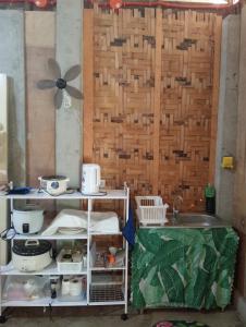 a kitchen with a sink and a wooden wall at Kalma Kubo Siargao in San Isidro