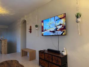 a living room with a flat screen tv on the wall at Casa Brisa Beach House in Dorado