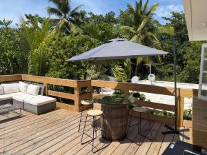 a patio with a table and an umbrella at Casa Brisa Beach House in Dorado