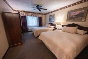 a hotel room with two beds and a ceiling fan at Hearthstone Inn & Suites in Cedarville