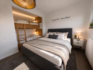 a bedroom with a large bed and bunk beds at Bergkultur Sauerland in Medebach