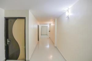 a hallway with white walls and a black door at Collection O Green Park Residency 3 in New Delhi