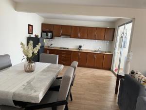 a kitchen and dining room with a table and chairs at AdHeDiLe & GIACAHER in Guadalupe +4 photos