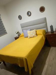 a yellow bed with a yellow blanket on it at AdHeDiLe & GIACAHER in Guadalupe