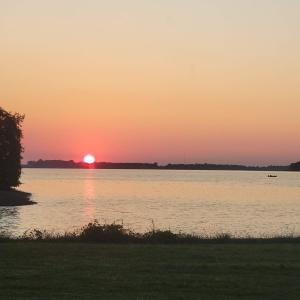 a sunset over a large body of water at Red Leaf Cottages in Lake Village +1 photo