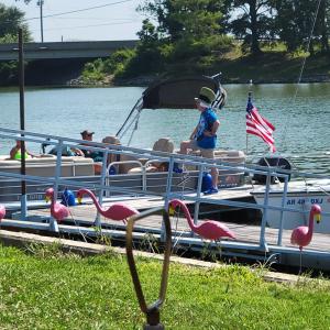 a group of people on a pontoon boat on the water at Red Leaf Cottages in Lake Village