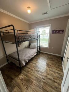 a bedroom with two bunk beds and a wooden floor at Red Leaf Cottages in Lake Village