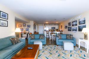 a living room with blue couches and a table at Pool Days & Water Fun Await: Lake Ozark Escape! in Lake Ozark