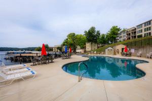 a large swimming pool with tables and chairs in a resort at Pool Days & Water Fun Await: Lake Ozark Escape! in Lake Ozark