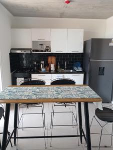 a kitchen with a table with chairs and a refrigerator at Departamento en Condominio in Luque