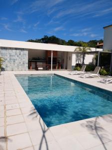 a swimming pool with two chairs and a house at Departamento en Condominio in Luque