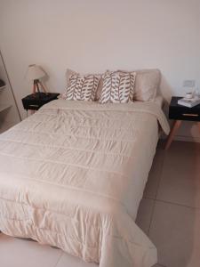 a white bed with pillows on it in a bedroom at Departamento en Condominio in Luque +16 photos
