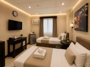 a hotel room with two beds and a television at Amax Inn Makati in Manila +69 photos
