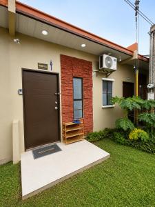 ein Haus mit einer großen Tür an der Vorderseite in der Unterkunft Harmony Villa in Tanza
