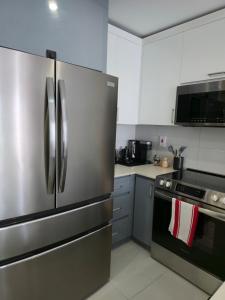 a kitchen with a stainless steel refrigerator and a stove at City View Luxe Condo in Mandeville