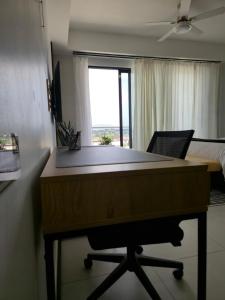 a desk in a room with a bed and a window at City View Luxe Condo in Mandeville