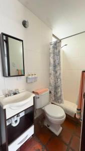 a bathroom with a toilet and a sink and a shower at Club Colonial Hotel in Huanchaco +25 photos