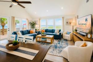 a living room with a blue couch and chairs at Beachfront Luxe, Ocean Views, Hot tub, Firepit, Sleeps 14 in Bolivar Peninsula