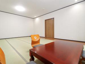 a conference room with a wooden table and a chair at サンバレーひぐち in Muikamachi +60 photos