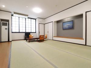 an empty room with a table and a bench at サンバレーひぐち in Muikamachi