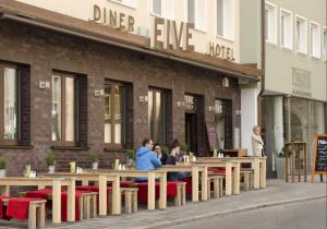 ludzie siedzący przy stolikach przed restauracją w obiekcie Hotel FIVE w Norymberdze