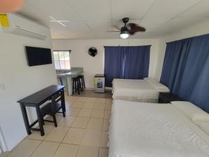 a room with three beds and a table and a desk at Ocean View in Big Corn Island
