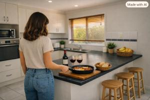 a woman standing in a kitchen with a bowl of food and wine at Canberra Stylish Escape in Harrison +5 photos