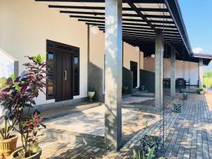 a house with a wooden door and a patio at wild elephant reach wilpattu in Nochchiyagama