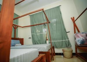 a bedroom with two beds and a window at Panofu Homestay in Moshi