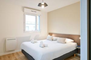 a bedroom with a large white bed with a window at Comfort Aparthotel Versailles, St Cyr l'Ecole in Saint-Cyr-lʼÉcole +58 photos