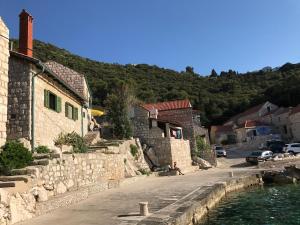 a village with buildings and a street and water at Lucica 1 Beachfront House in Lastovo
